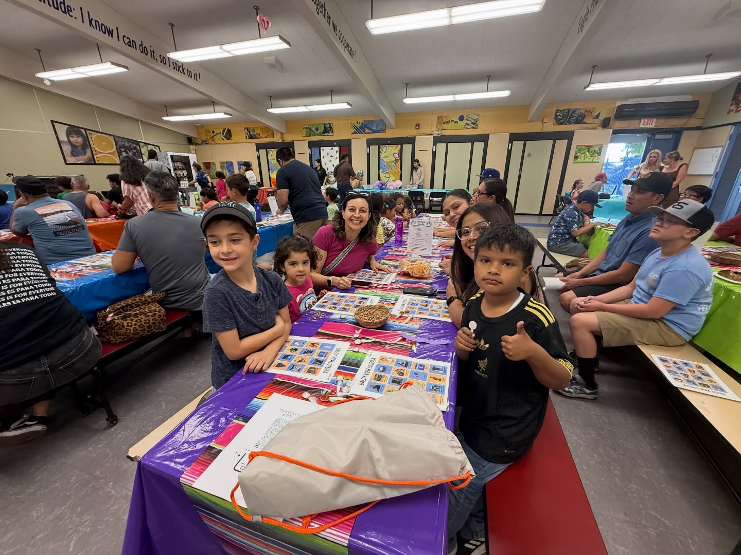 Baldy View families and students gathered around colorful Lotería tables