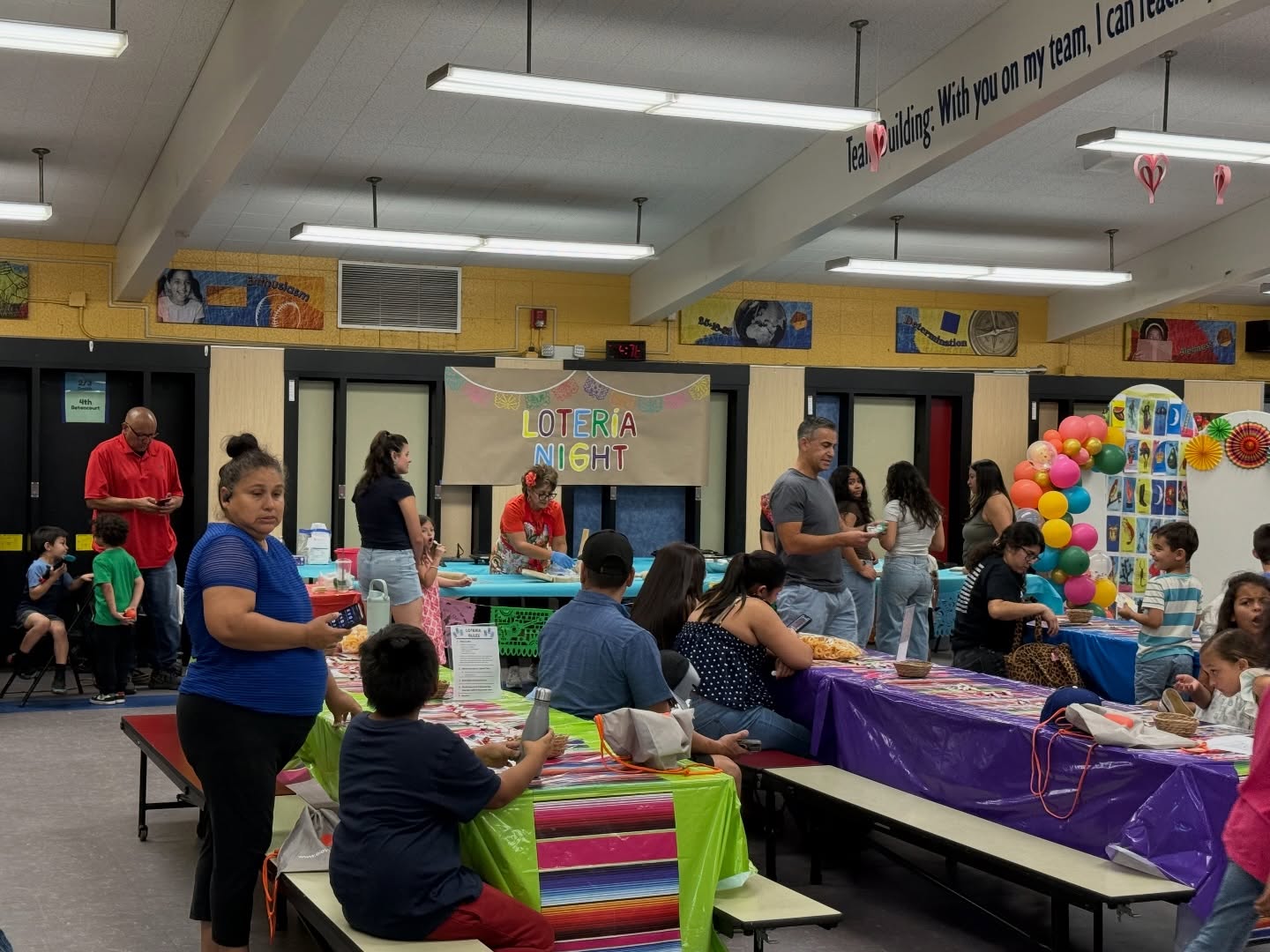 Baldy View families and students gathered at Lotería Night beneath the event sign