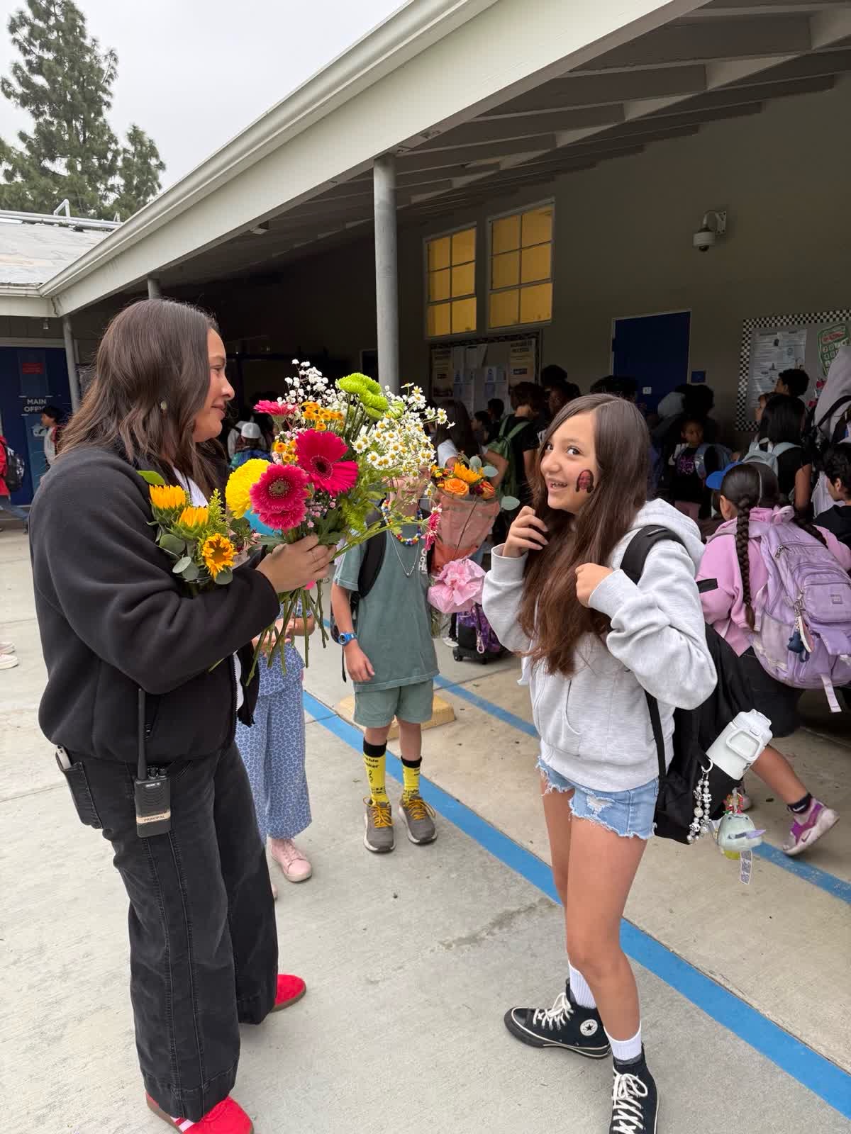 Principal Angela Huerta greeting Baldy View students with flowers